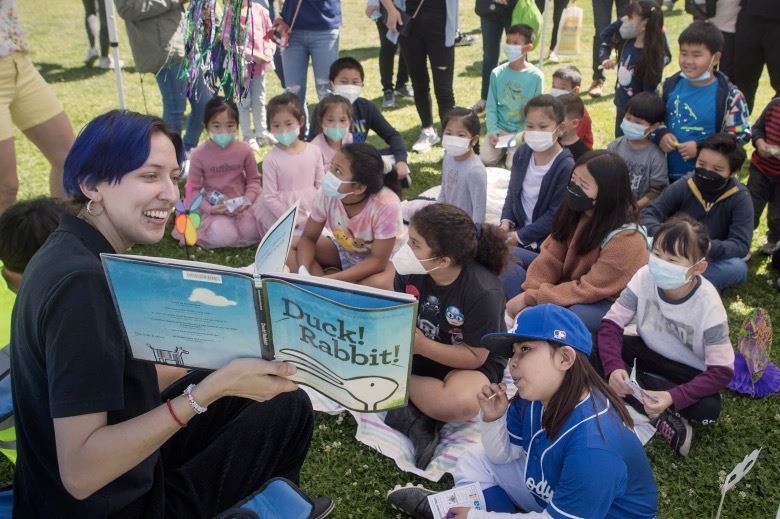 Librarian reading to children at the park